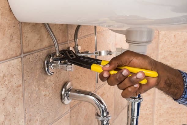 Close-up Of Plumber's Hand Repairing Sink In Bathroom Close-up Of Plumber's Hand Repairing Sink In Bathroom